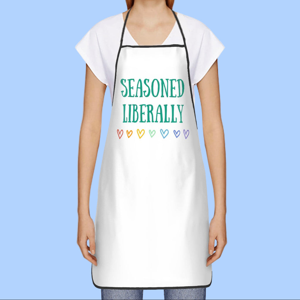 Person wearing a white apron with 'Seasoned Liberally' text and colorful hearts on a white background