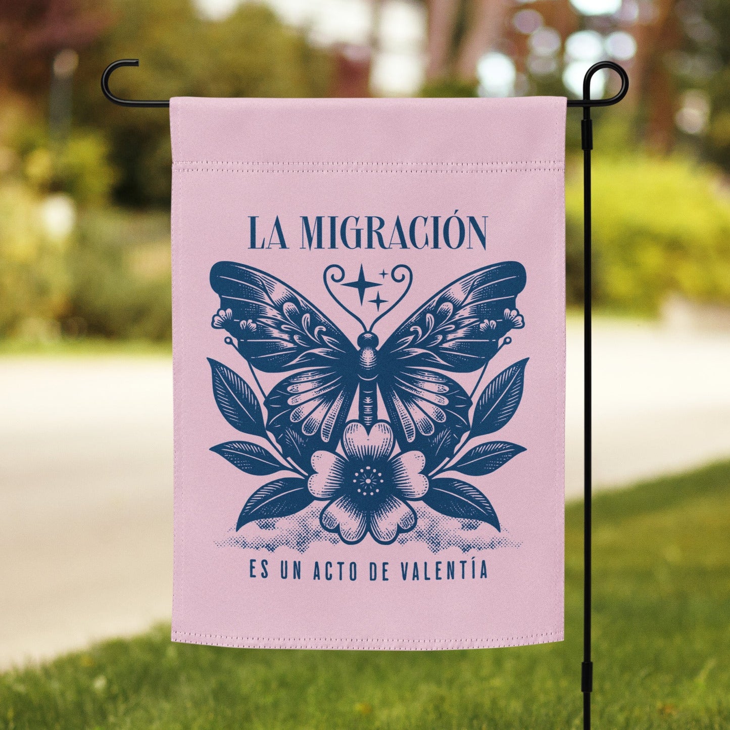 Pink garden flag with butterfly design and text on a grassy lawn